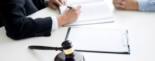 A criminal defense attorney signing a document with a client