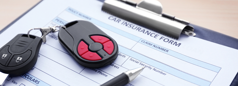 Car insurance form with keys and a pen on top