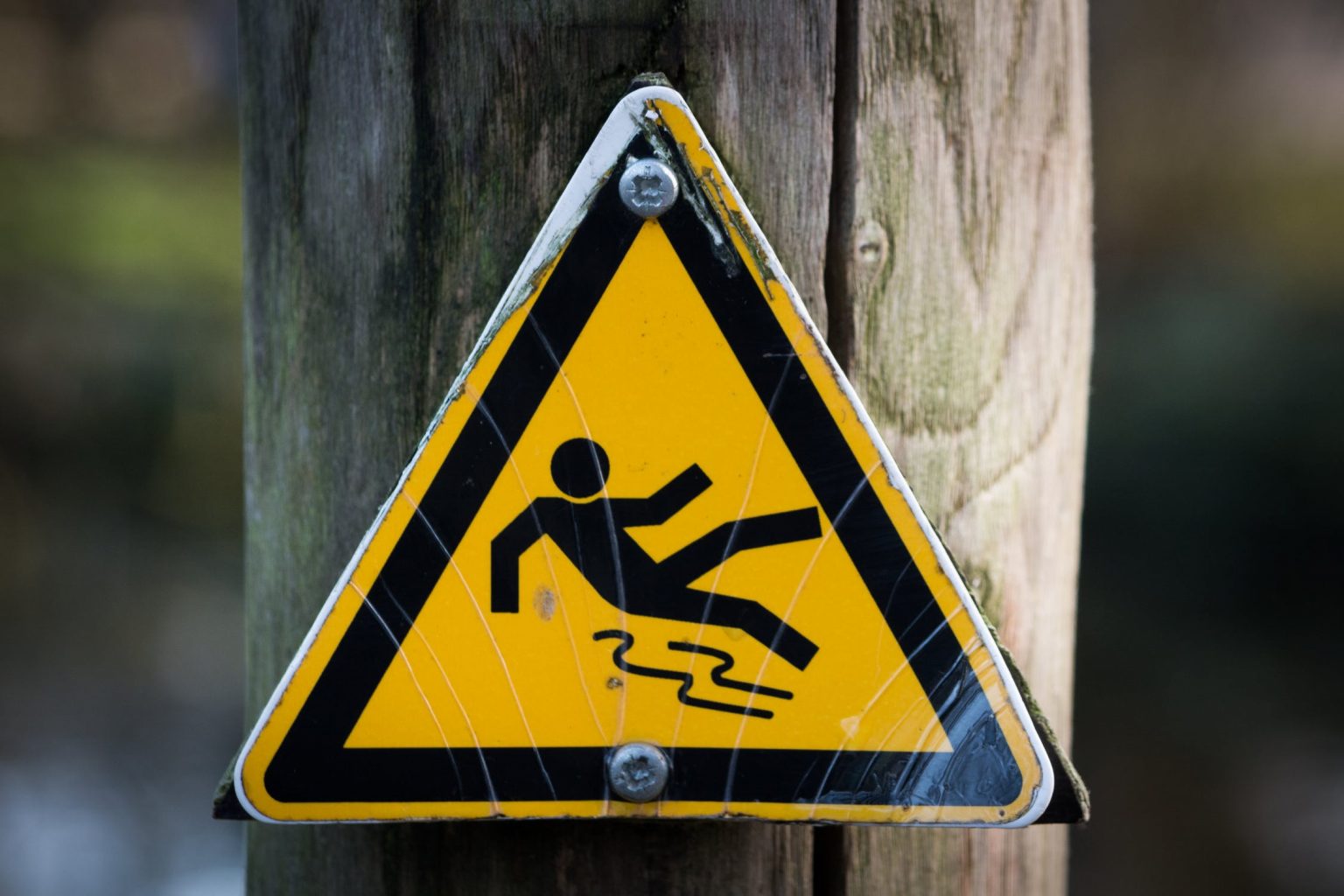 Worn slip and fall sign attached to a post