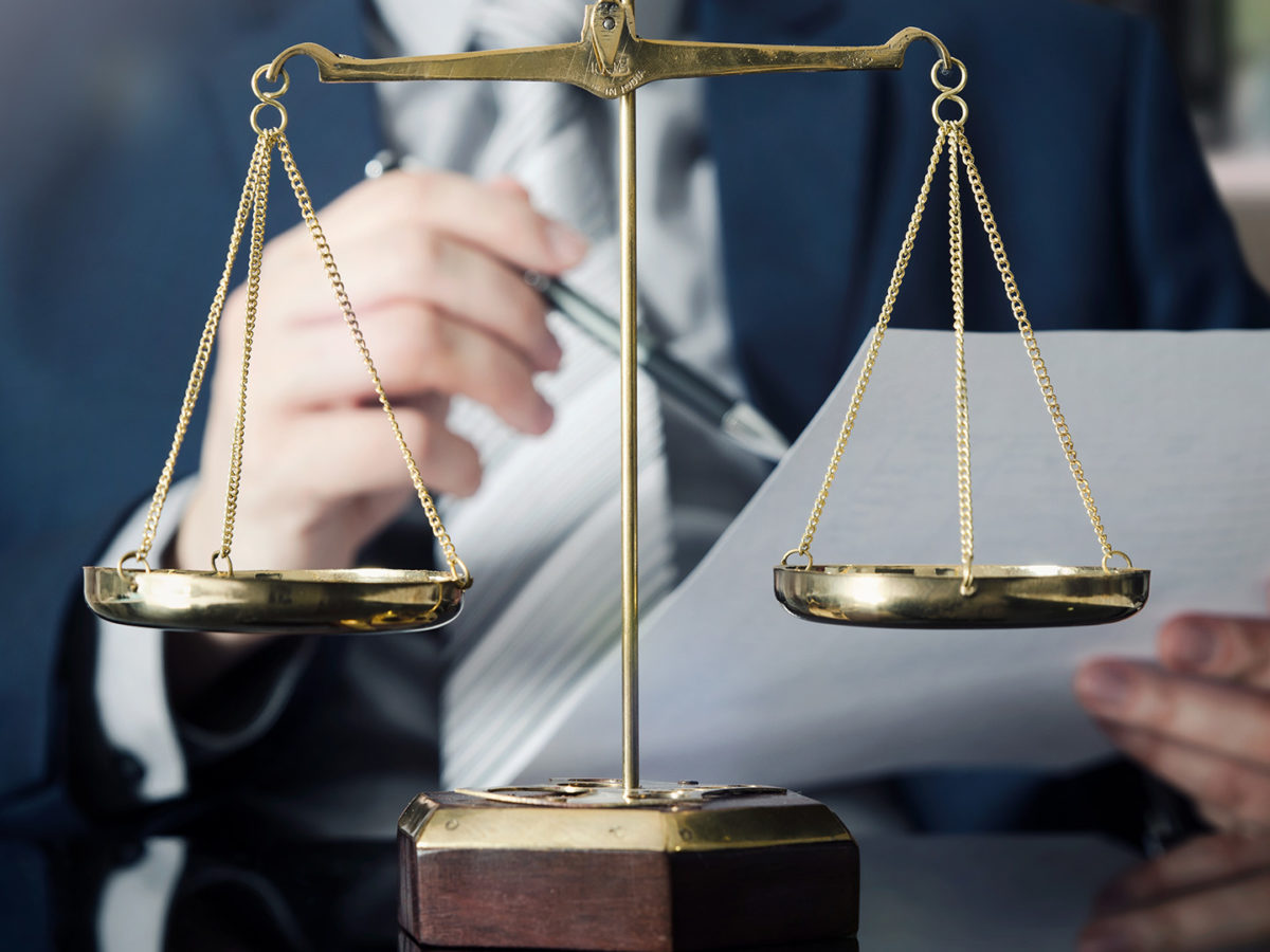 Lawyer doing paperwork in front of a US justice symbol