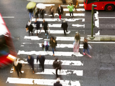 Aerial view of pedestrians walking through crosswalk.
